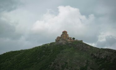 a castle sitting on top of a lush green hillside