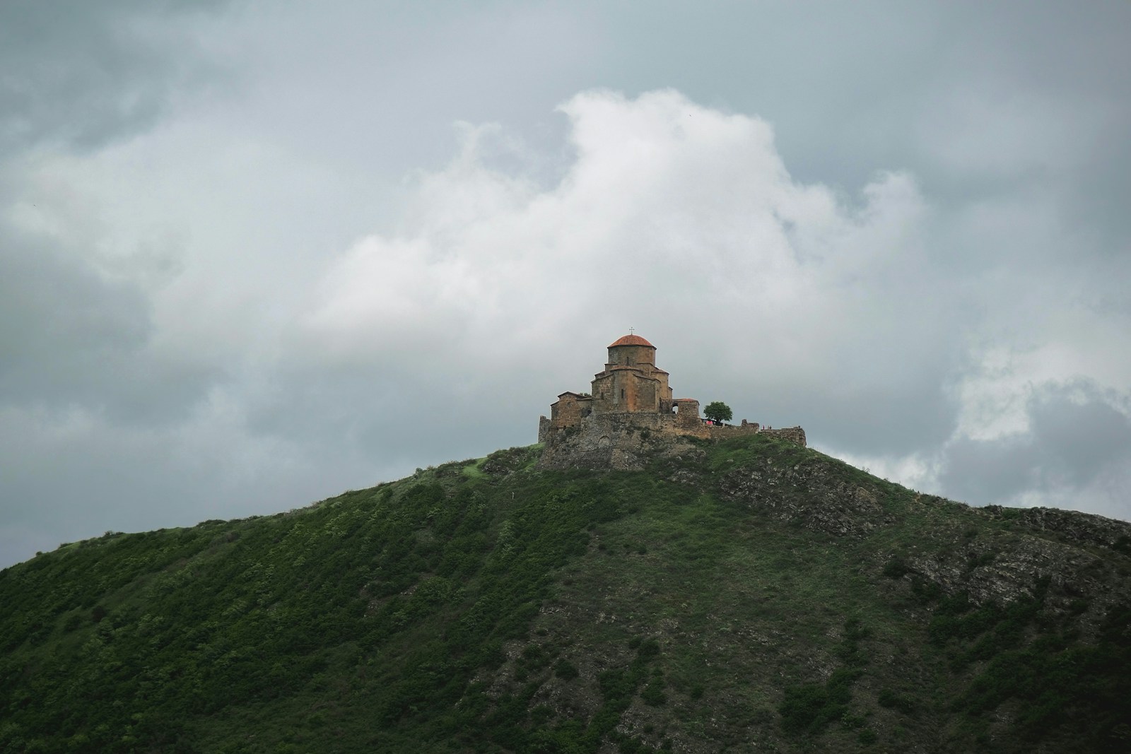 a castle sitting on top of a lush green hillside