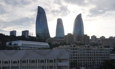 The flame towers illuminate the city skyline.